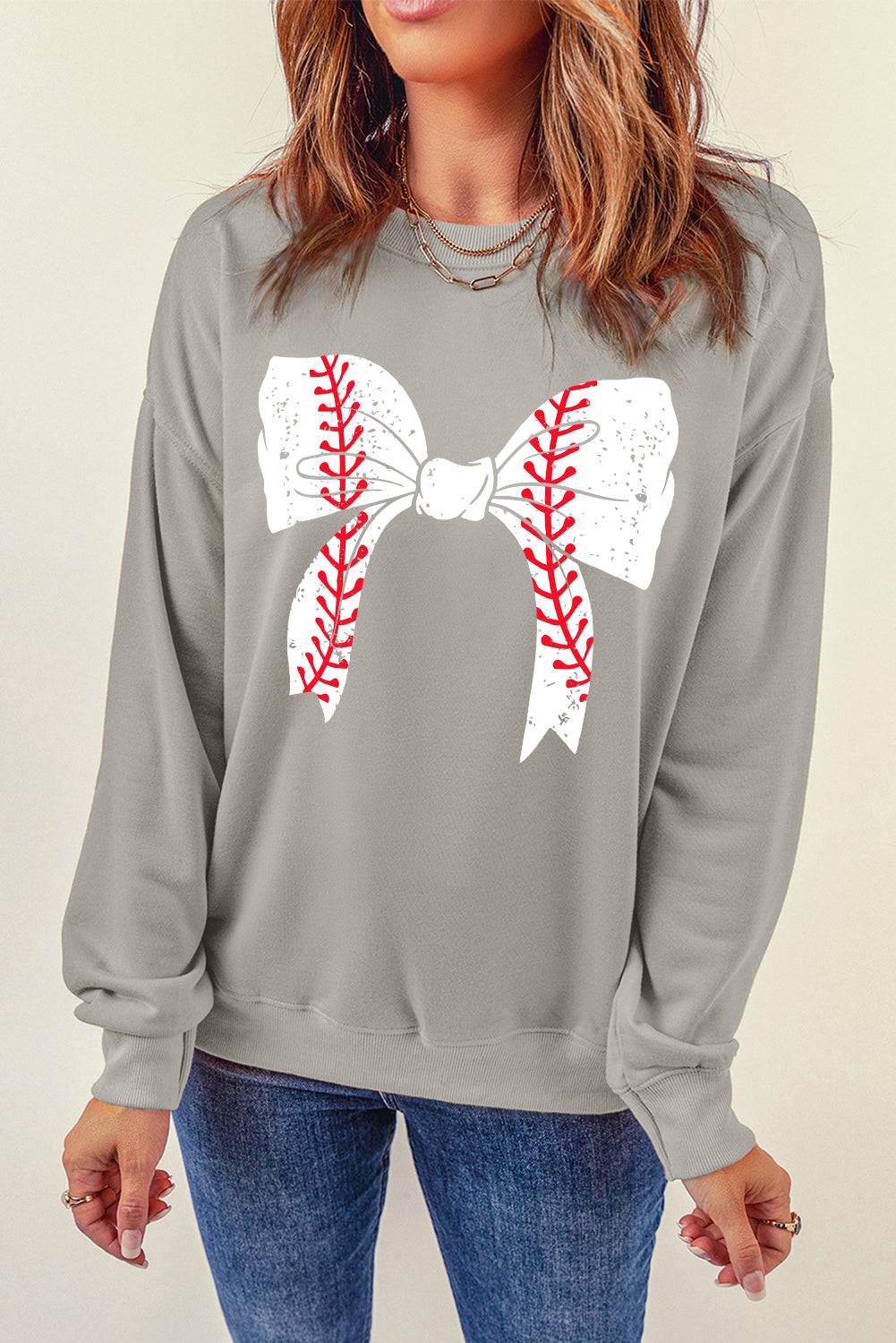 a woman wearing a baseball bow tie sweatshirt